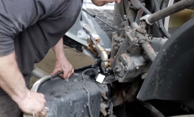Mechanic performing hands-on engine repair on a heavy-duty truck